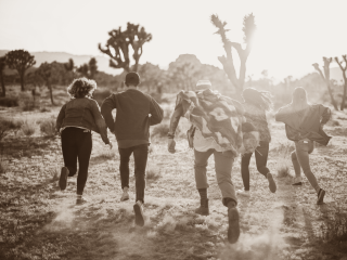 5 junge Menschen rennen im Freien auf ein imaginäres Ziel zu